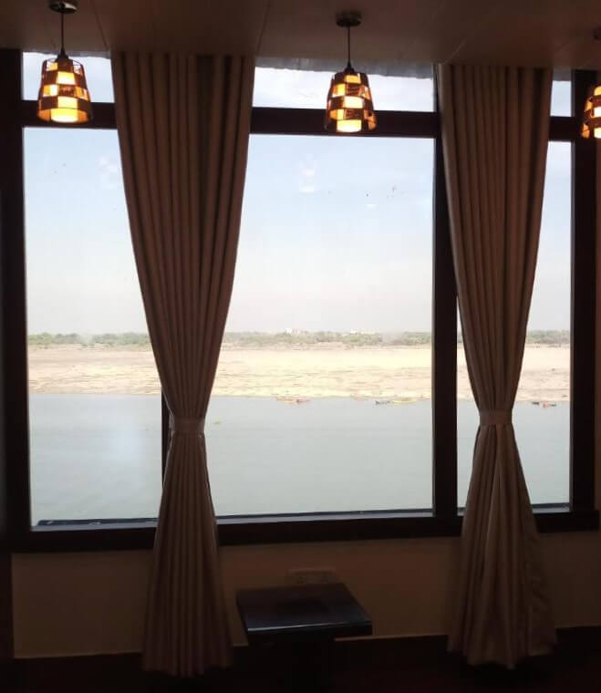 Comfortable work desk by window overlooking Varanasi cityscape and River Ganga at Rashmi Guest House